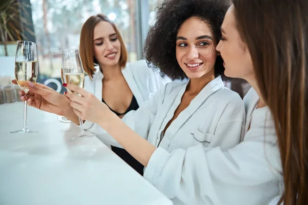 Feliz joven mujer de pie y sosteniendo champán — Foto de Stock