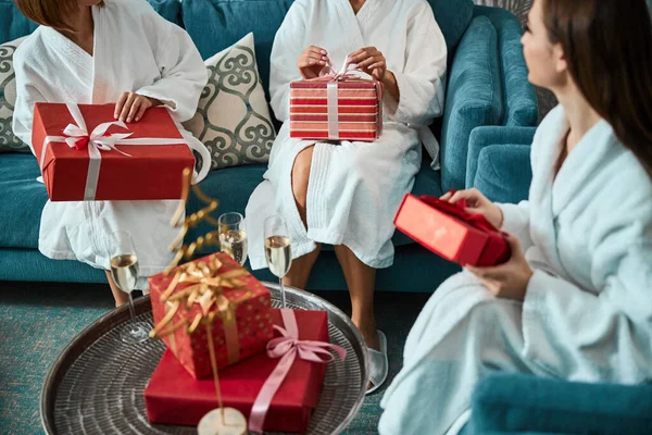 Drie beste vrouwelijke vrienden wisselen geschenken uit terwijl ze chillen in het hotel — Stockfoto