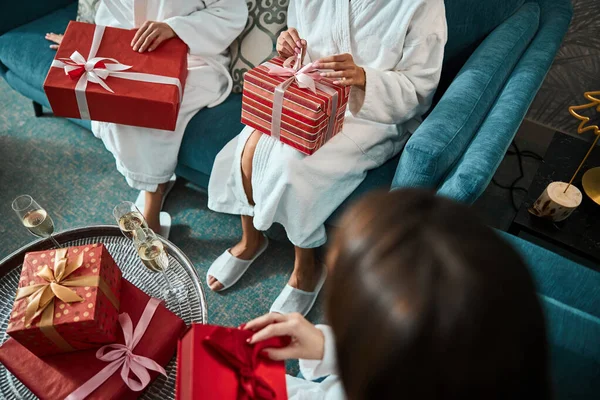 カジュアルな家庭服を着た女性がクリスマスプレゼントを開く — ストック写真