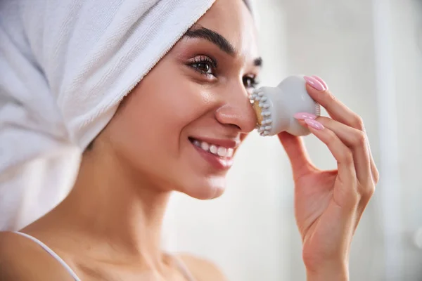 Joven alegre usando un masajeador facial después de la ducha —  Fotos de Stock