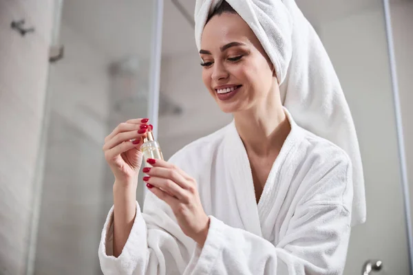 Schöne junge Frau genießt ihre Hautpflege Routine im Badezimmer — Stockfoto