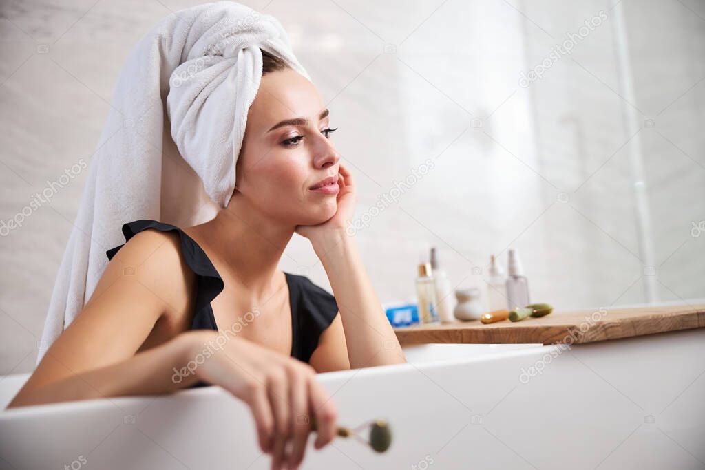 Lovely young lady chilling in the bathtub