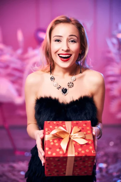 High-spirited woman with a present looking ahead — Stock Photo, Image