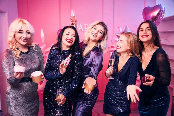 Pretty women in cocktail dresses laughing heartily — Stock Photo, Image