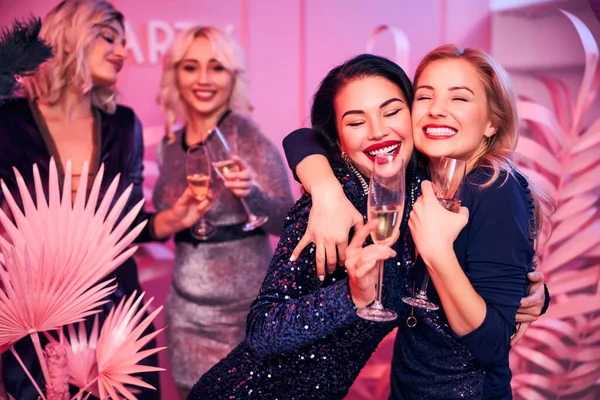 Sonriente elegante caucásico damas sosteniendo alto gafas — Foto de Stock