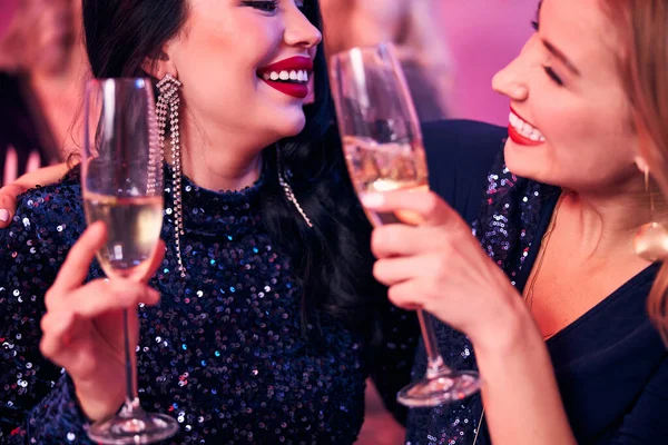 Två glada honor som klamrar sig fast vid sina champagneflöjter — Stockfoto