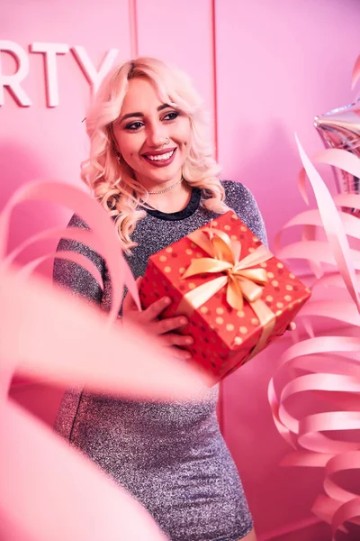 Female in a sequin dress holding a gift — Stock Photo, Image