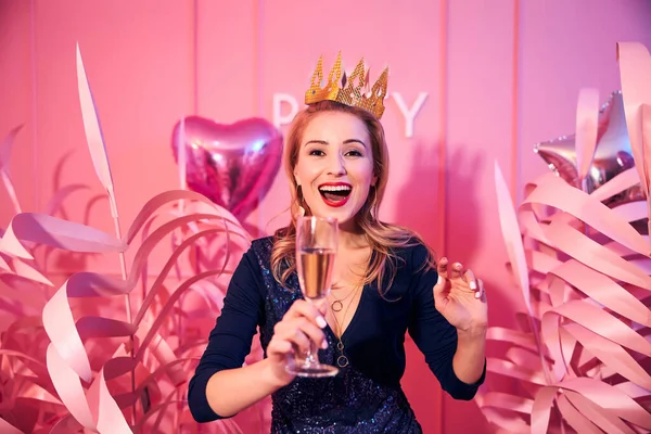 Glamorous merry lady holding a champagne flute — Stock Photo, Image