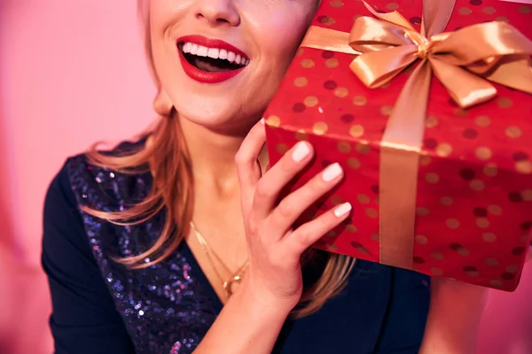 Joyous young female holding a present box — Stock Photo, Image