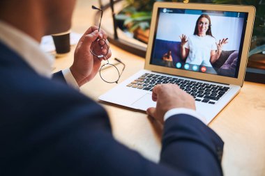 Online öğrenci dizüstü bilgisayarının önünde oturuyor.