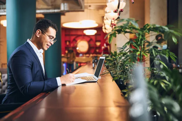 Zakenman in spektakels notities maken met een balpen — Stockfoto