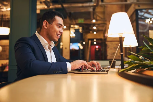 Gelukkig donkerharig jong telecommuter beantwoorden van een e-mail — Stockfoto