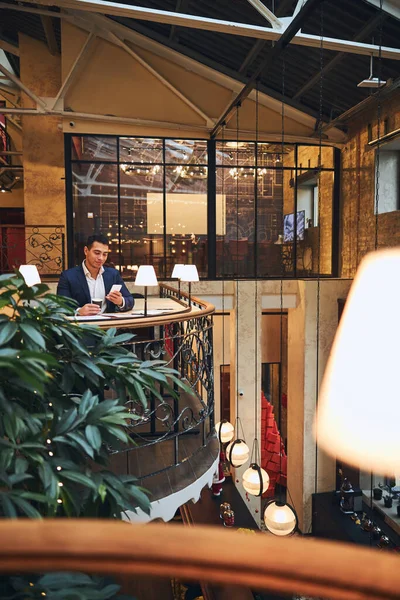 Hombre con un celular tomando un café — Foto de Stock