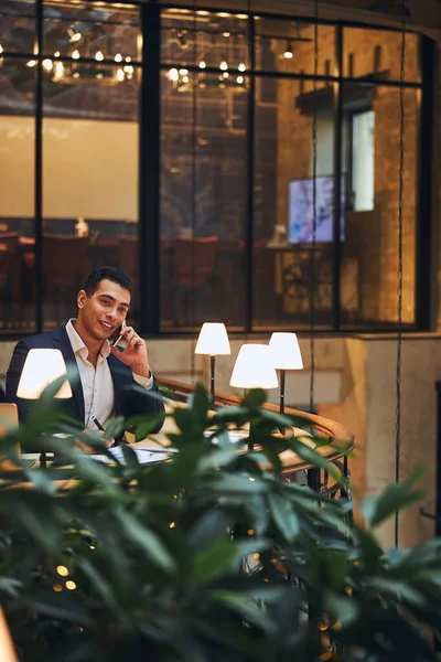Dark-haired business person talking on his smartphone — Stock Photo, Image