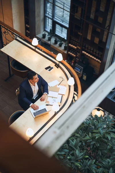 Pensativo freelancer masculino con un portátil mirando hacia otro lado —  Fotos de Stock