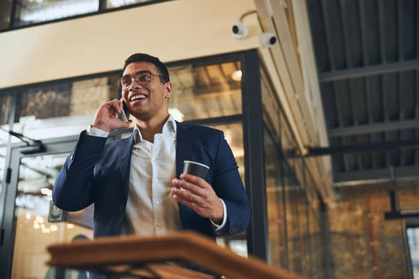 Vrolijke ondernemer heeft een telefoongesprek tijdens de koffiepauze — Stockfoto