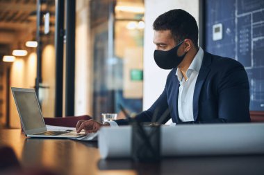 İş yerindeki bilgisayarı kullanan koyu renk saçlı mühendis.