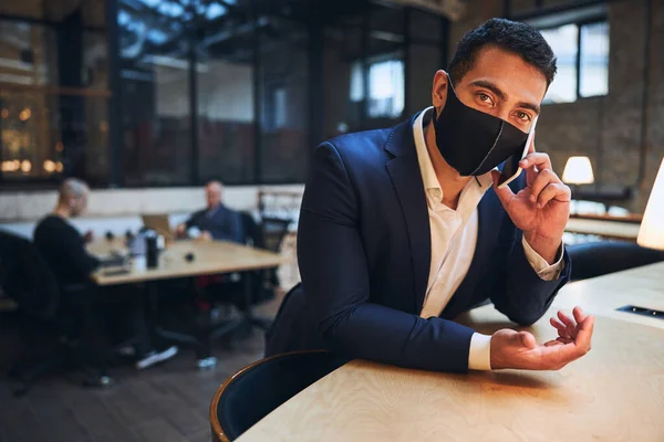 Joven hombre de negocios moreno que se comunica en el teléfono inteligente —  Fotos de Stock