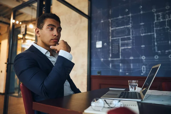 Jeune ingénieur pensif assis à son ordinateur — Photo