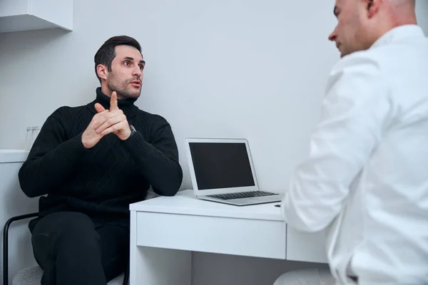 Aantrekkelijke man die klaagt bij therapeut in kliniek — Stockfoto