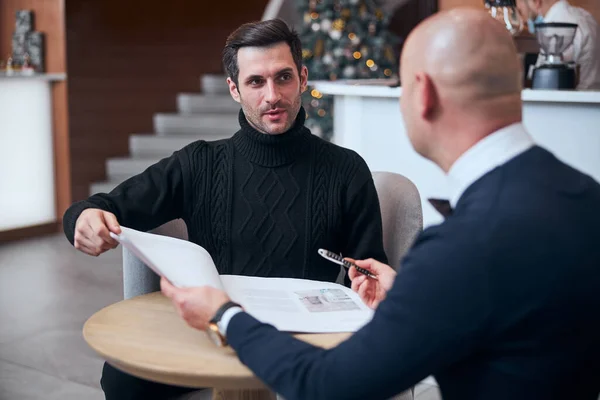 Two elegant men talking about papers in lobby — Stock Photo, Image