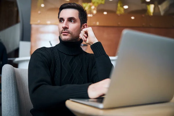 Snygg ung affärsman som arbetar online på laptop inomhus — Stockfoto