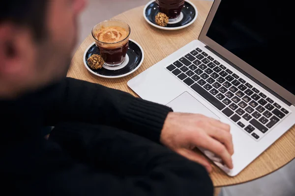 Man som arbetar på anteckningsbok och dricker kaffe — Stockfoto