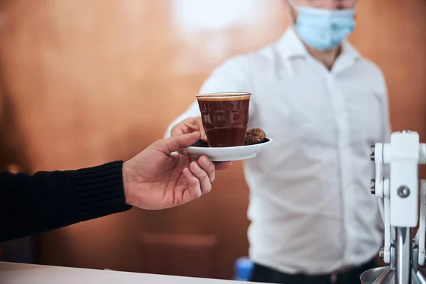 Kelner podający kawę człowiekowi podczas kwarantanny — Zdjęcie stockowe