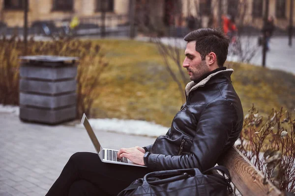 Şehir sokağında dizüstü bilgisayar kullanan genç adam. — Stok fotoğraf
