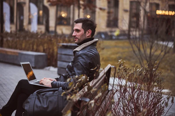 Avslappnad stubbad man med laptop i parken — Stockfoto