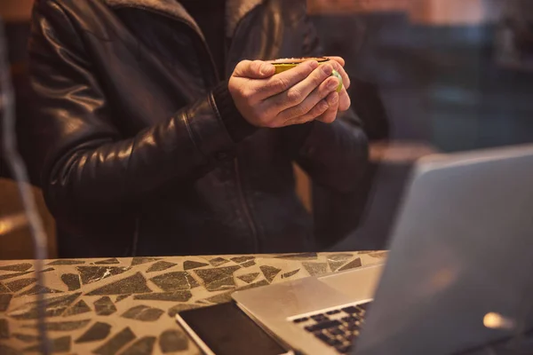 Masculino com bebida quente e caderno no café — Fotografia de Stock