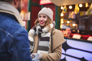 Güzel, gülümseyen bir kadın erkek arkadaşıyla dışarıda vakit geçiriyor.