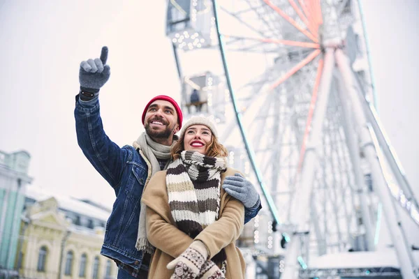 Buona giovane coppia visita parco divertimenti in inverno — Foto Stock