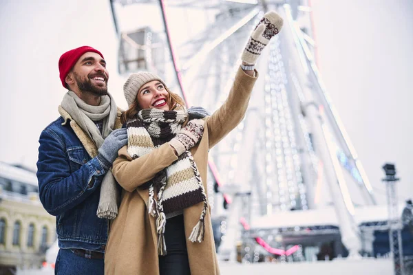 Счастливая молодая пара веселится в центре города зимой — стоковое фото