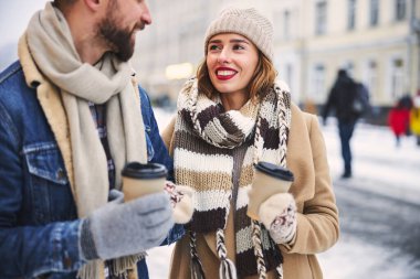 Şehir merkezinde sıcak bir şeyler içen mutlu çift.