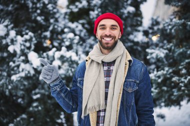 Karlı havada yürüyen neşeli genç adam