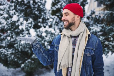 Mutlu genç erkek kışın ormanda yürüyor