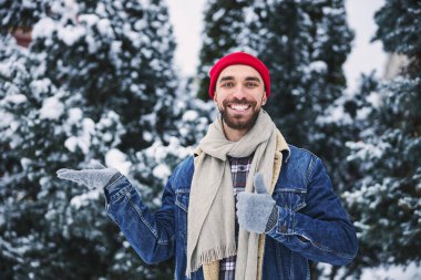 Kış ormanlarında yürüyen neşeli yakışıklı adam.