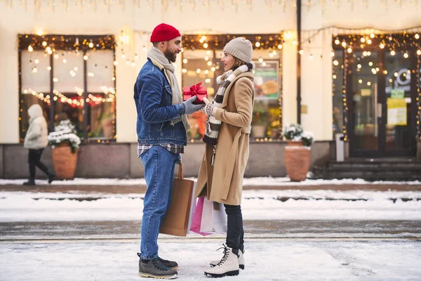 Ragazzo premuroso che dà regalo alla donna amata in inverno — Foto Stock
