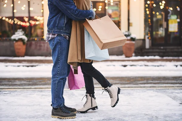 Coppia felice che si abbraccia in strada innevata dopo lo shopping — Foto Stock