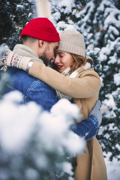 Счастливая пара, встречающаяся среди деревьев, покрытых снегом — стоковое фото