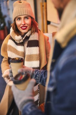 Serene genç bayan dışarıda bir adamla kahve içiyor.