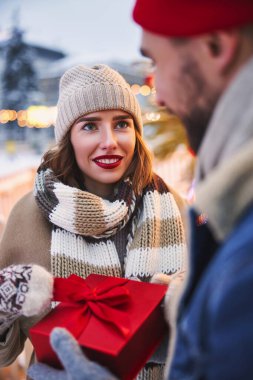 Dışarıda Noel hediyelerini değiş tokuş eden neşeli bir çift.