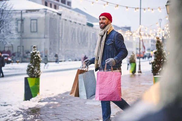 Jovem alegre comprando presentes para o Natal — Fotografia de Stock