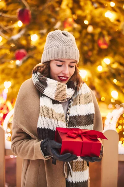 Mutlu kadın dışarıda Noel Ağacı 'nda hediye alıyor — Stok fotoğraf