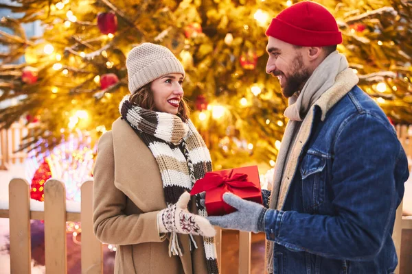 Sevgili adam dışarıda sevgilisine Noel hediyesi veriyor. — Stok fotoğraf