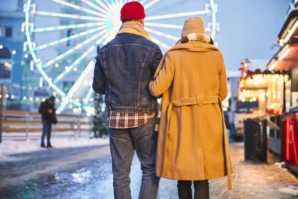 Kochająca para spacerująca w pobliżu parku rozrywki w zimie — Zdjęcie stockowe