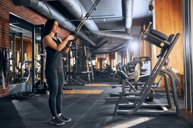 Gülümseyen atletik kadın spor salonunda çalışıyor.