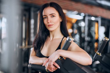 Gülümseyen fit kadın spor salonunda çalışıyor.