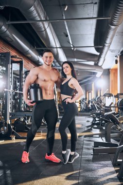 Gülümseyen sporcu çift spor salonunda antrenman yapıyor.